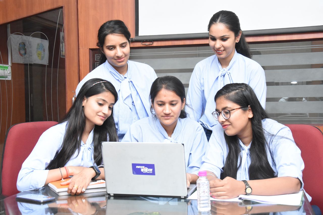 Services A group of young South Asian women working together on a laptop in a Jaipur office.