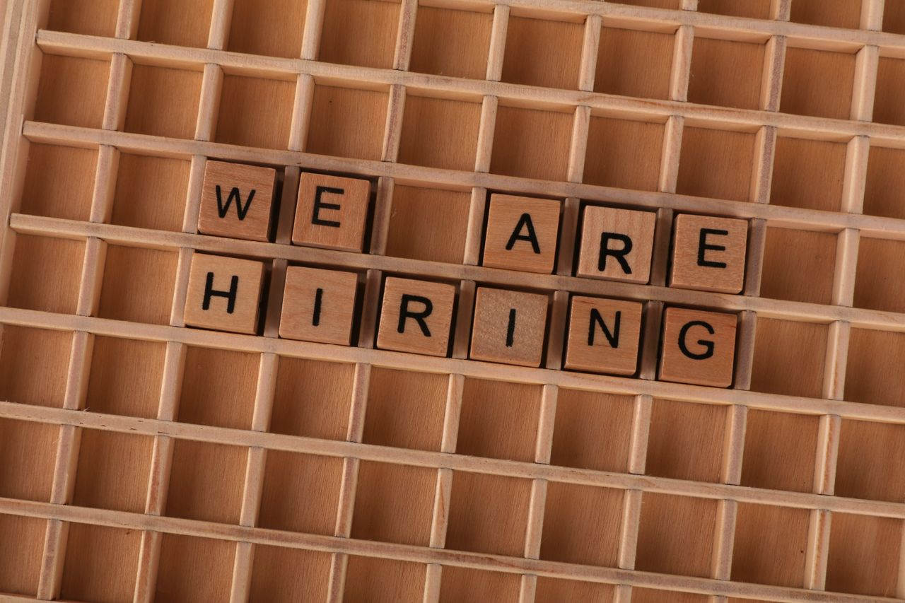 Services Wooden tiles on a board forming the phrase 'We Are Hiring', ideal for job announcements.